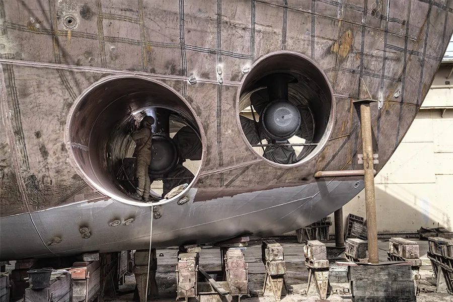 Inspektion eines Bugstrahlruders am Rohbau eines Schiffs in der Werft